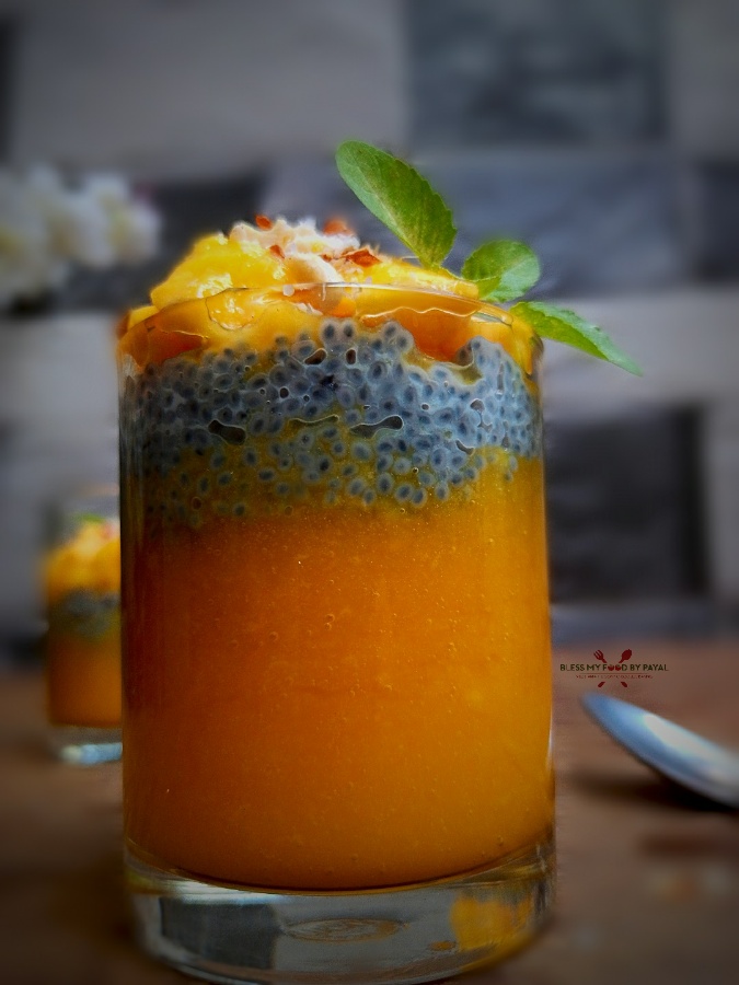 Mango Sabja pudding parfait | mango basil seeds pudding | mango sabja pudding recipe with step wise pictorial and video recipe.  Mangoes are in the season & we wish to make out every possible recipe out of it. Though this is just a comic expression because mango is so versatile that you can not end up using it. Lol.  Mango pudding is something very common but assembling it with sabja wilk not just make it different but most healthy dessert too.  Sabja, popularly known as basil seeds, falooda seeds, tukmaria seeds or babri byol is full of health benefits. During this highly hot and humid environment, sabja helps in reducing the body heat.   It is also helpful in weight loss, controlling blood sugar levels, treating acidity, good for skin and hair, relieves constipation and bloating and cures cough and flu.  So lets begin with the recipe.  FOR LOWER LAYER (Mango puree)  1 mango (ripe/big size) 2 tsp Sugar (optional)  FOR MIDDLE LAYER (Sabja)  3 tbsp sabja/basil seeds 1/2 cup milk (use coconut milk, if vegan) 2 tsp sugar 1/2 tsp vanilla essence  FOR TOP LATER (Mango chunks & nuts)  1 Mango (medium size) Nuts of your choice Basil or mint leaves  MAKING OF LOWER LAYER (Mango puree)  Take the pulp out of mango and add to a blender.  Add sugar. You can skip sugar if mango is quite sweet or can replace sugar with honey or maple syrup.  Blend to a smooth puree and keep aside.  MAKING OF MIDDLE LAYER (Sabja)  Take milk in a bowl and add sugar and vanilla essence. Here too, sugar can be replaced with honey or maple syrup. Mix well.  Add basil seeds and mix again so that seeds get soaked in milk properly.  Rest 1 hour or until the seeds are puffed up.  After 1 hour, the seeds must have soaked almost entire milk and have turned into a thick jelly kind. Keep aside.  MAKING OF TOP LAYER (Mango chunks & nuts)  Cut mango in a way that you get small chunks out of it.  Also roughly chop the nuts you wish to add. We used almonds, cashew and desiccated coconut.  LAYERING  Take a serving glass and first pour mango puree in it till the glass is 1/3rd filled. Level it with a spoon.  Now add puffed sabja till the glass is 2/3 filled. Level it too.  At last top with chunks of mango and sprinkle chopped nuts over the chunks.  Garnish the serving glass with basil or mint leaves.  Mango Sabja pudding is ready. Make sure it is chilled before serving.  NOTES  You need to begin with the making of middle layer first because it needs some time to get completed.